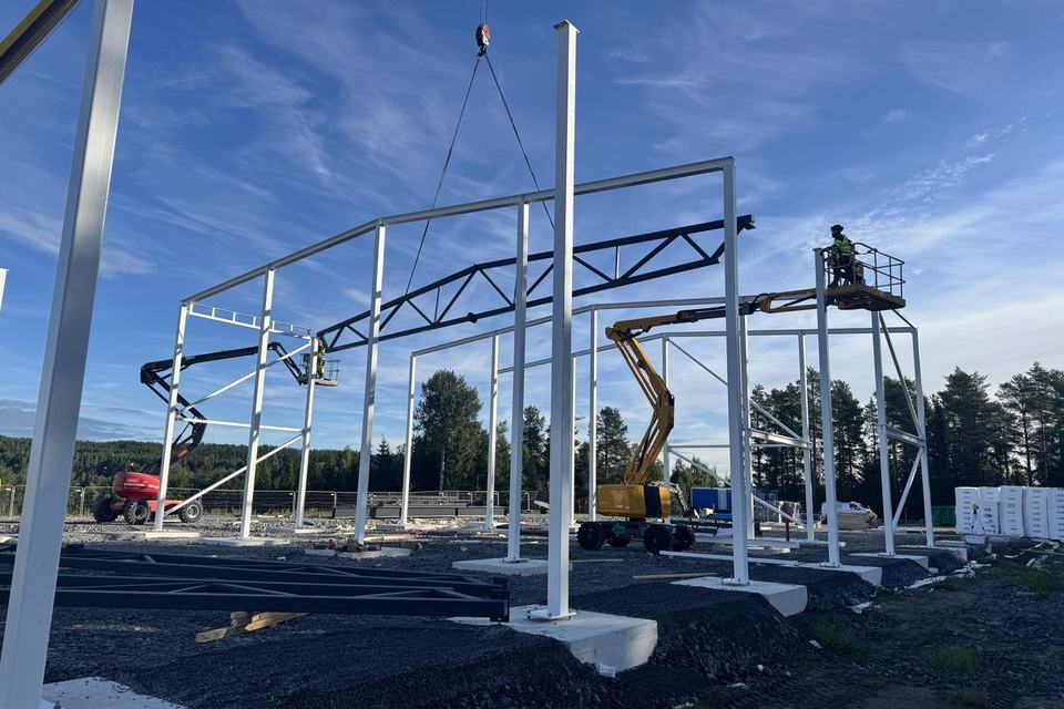 Crane lifting a roof truss onto steel columns, Renta rental centre